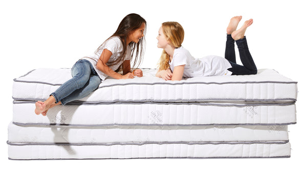 Girls-sitting-on-stack-of-organic-kids-mattresses-Huckleberry-kids-rooms