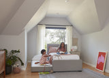 Dorma Rae Kids bed, upholstered in Nordic Grey fabric, with trundle bed, lifestyle photo girls, sold by Huckleberry Kids Rooms